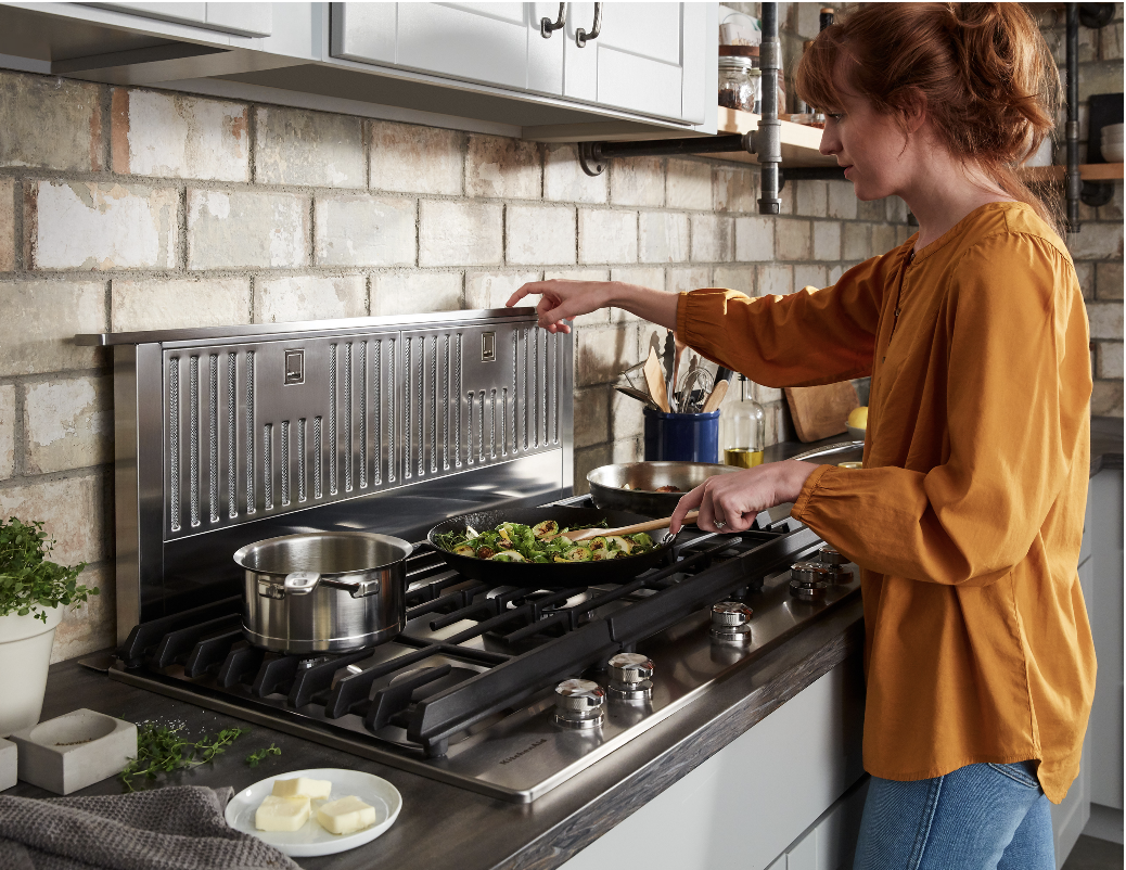 woman cooking at a kitchenaid gas range oven